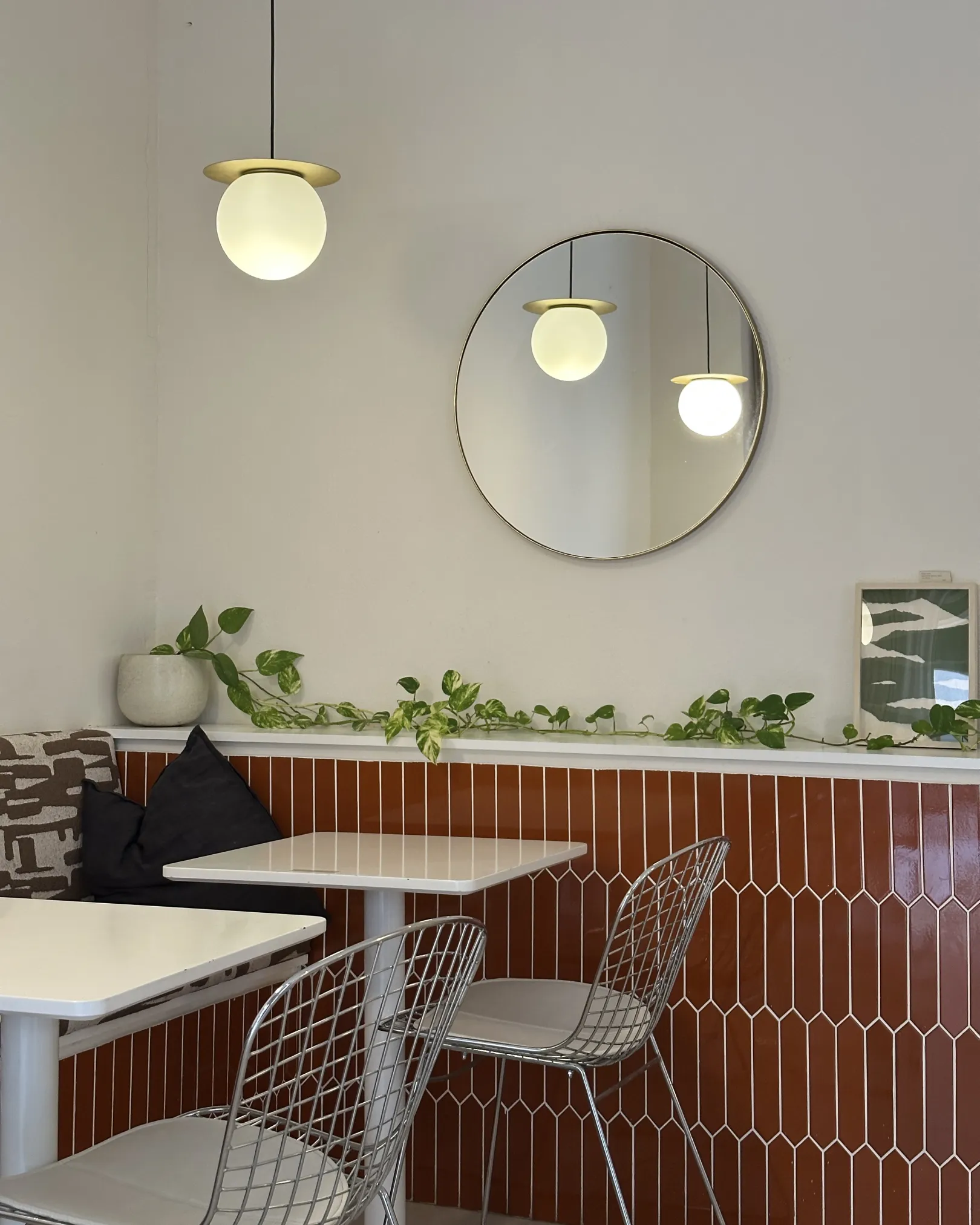 Banquette seating and small tables against terracotta tiling inside Casa Fran, El Carmen, Valencia