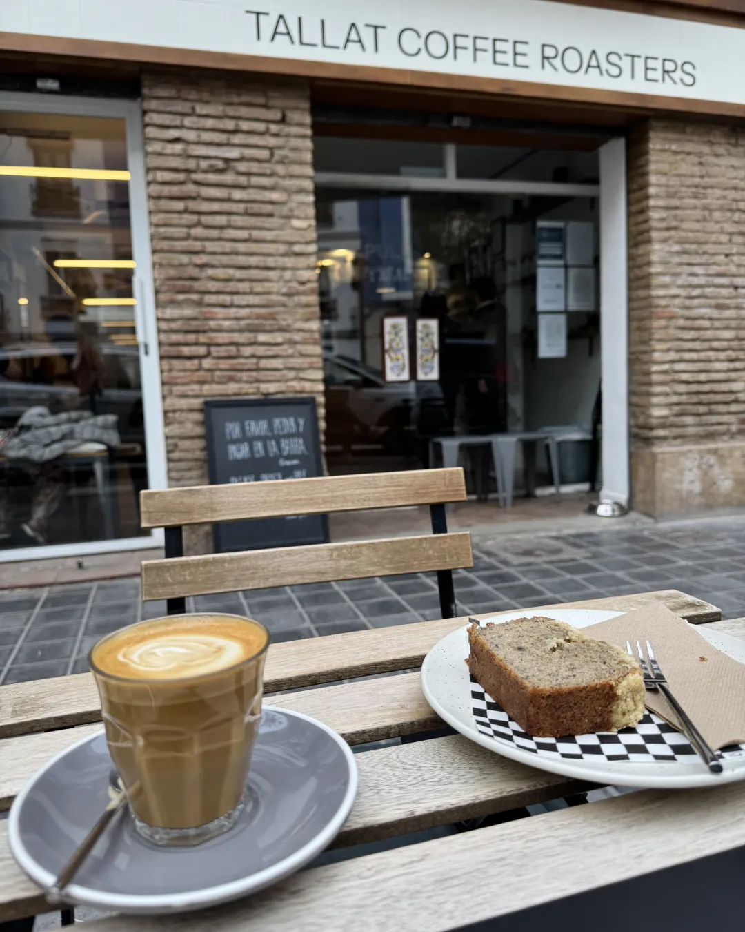Cortado and cake on a terrace table outside Tallat Coffee Roasters, El Cabanyal, Valencia